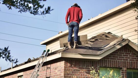 Man standing on roof with shingles pulled up