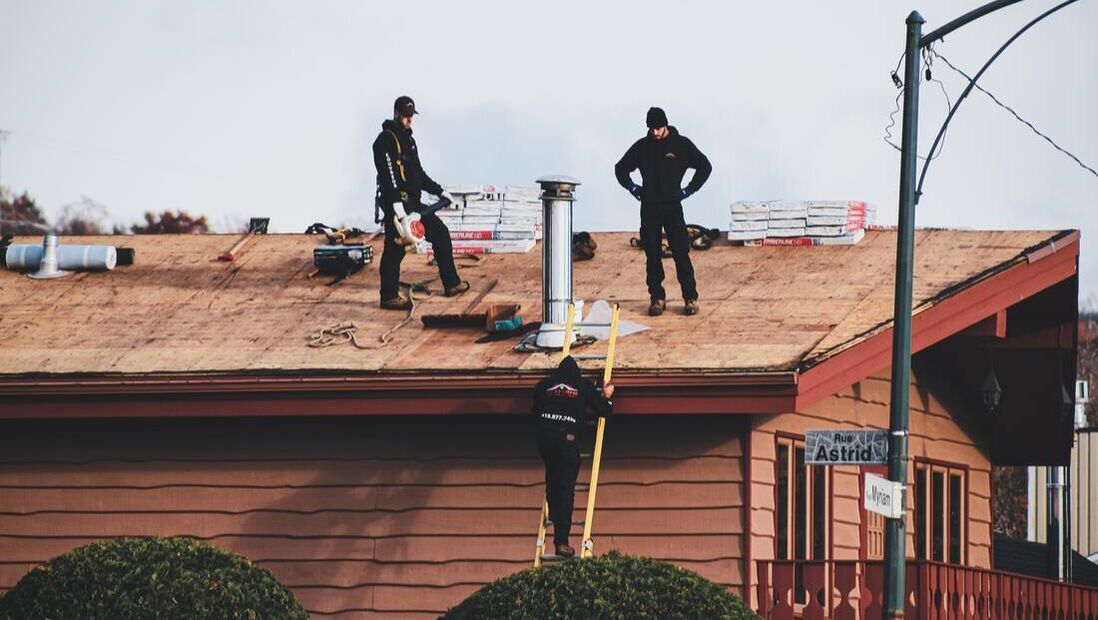 3 men on a bare roof working to replace it